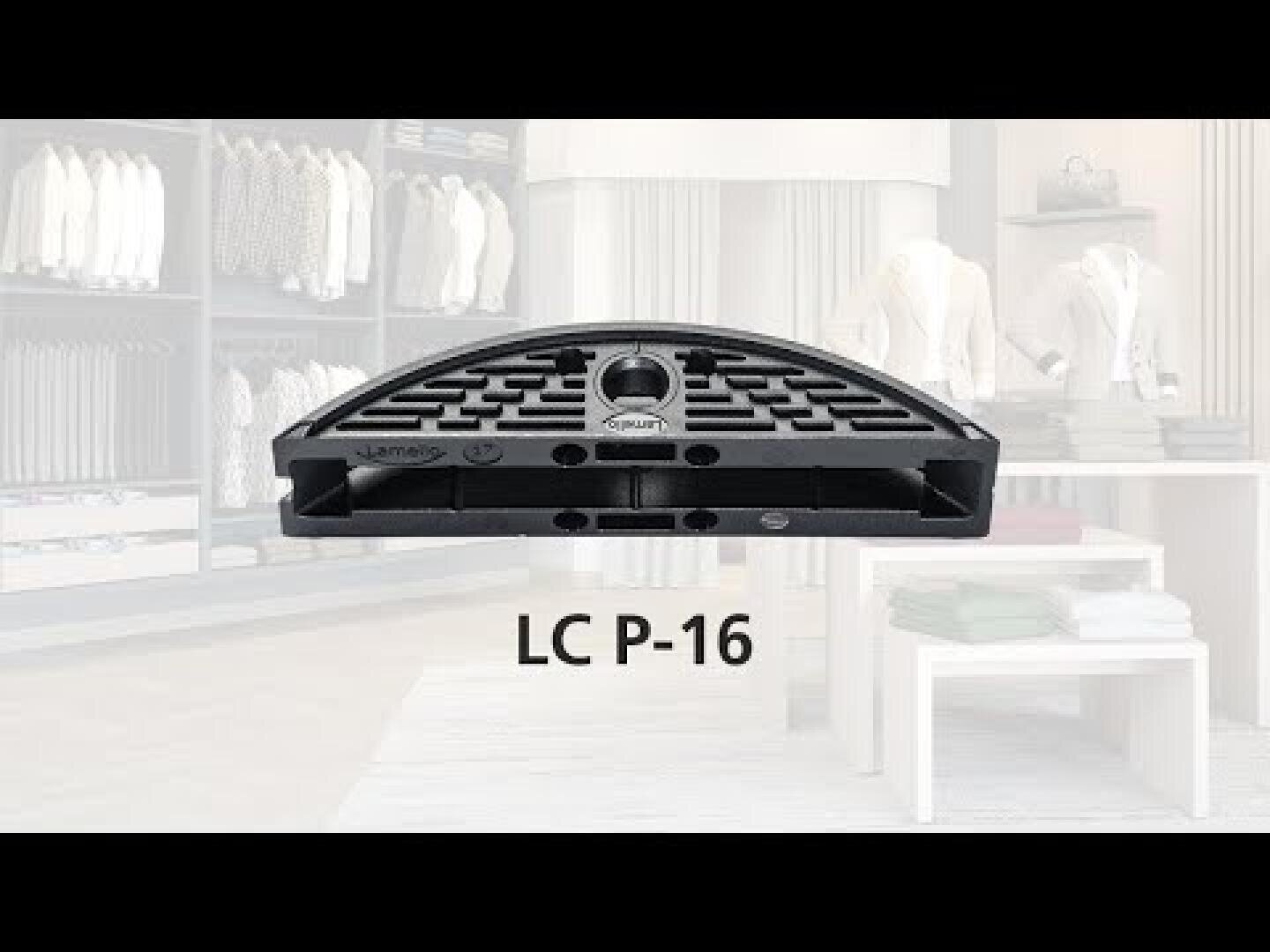 Un accessoire vestimentaire en plastique noir, en forme de demi-cercle, portant l'inscription LC P-16, sur fond flou d'un magasin de vêtements moderne.