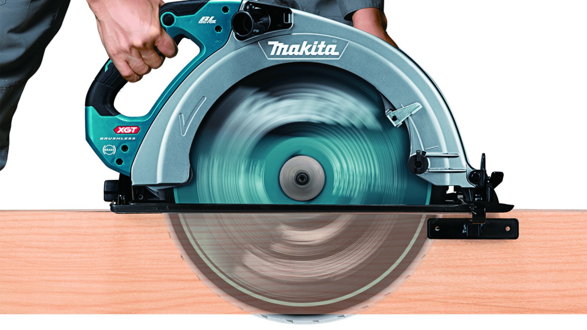 Une personne utilise une scie circulaire Makita pour couper une pièce de bois. La lame de la scie tourne rapidement et la poussière de bois est visible.