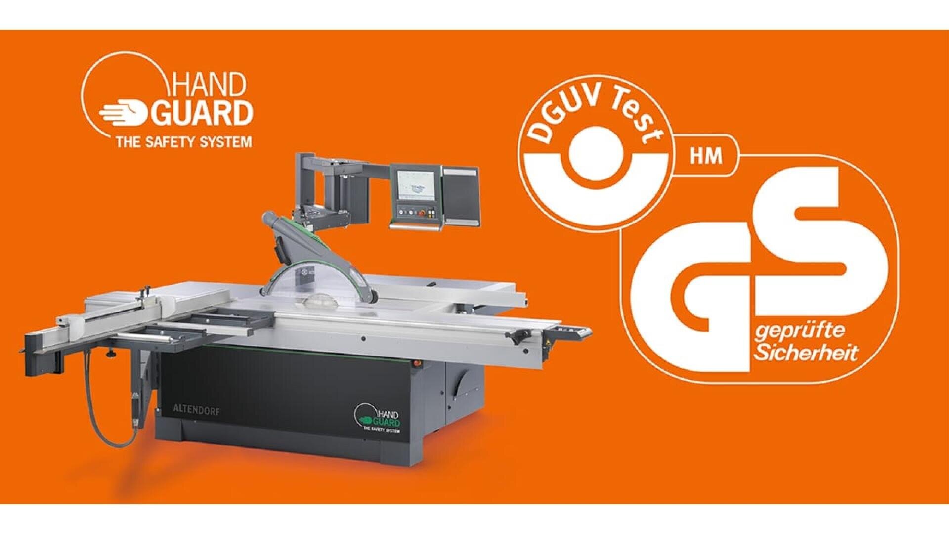 Une scie à format à affichage numérique est présentée sur un fond orange avec les logos de certification de sécurité "HAND GUARD THE SAFETY SYSTEM", DGUV Test et GS geprüfte Sicherheit.