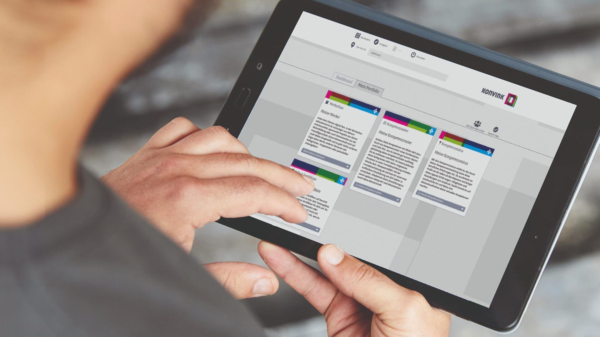 Eine Person hält ein Tablet in der Hand und interagiert mit dem Finger mit einer Projektmanagement- oder Taskboard-App, die mehrere farbcodierte Karten in Spalten anzeigt.