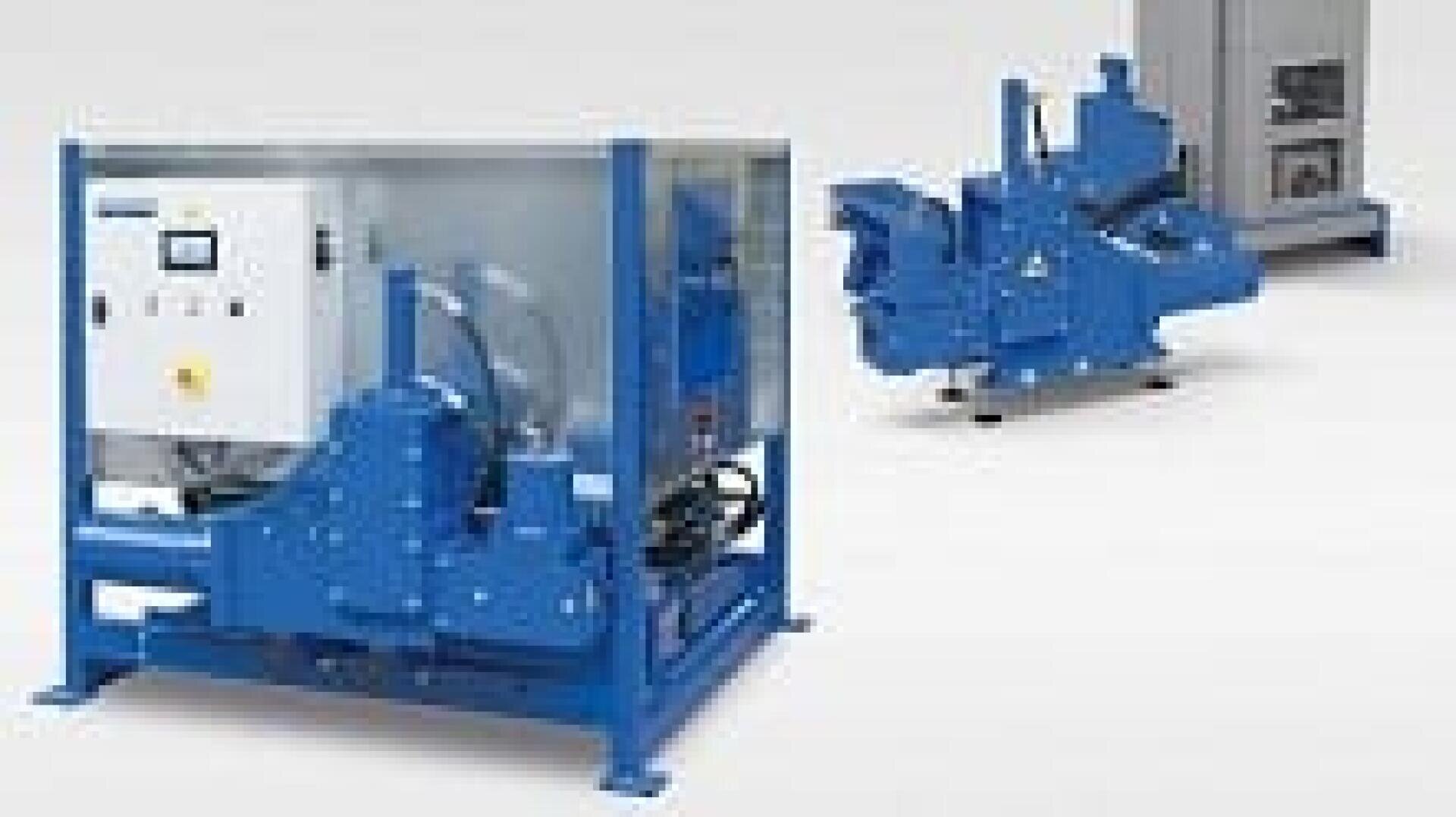 Deux machines industrielles bleues sont présentées sur un fond clair ; l'une est équipée d'un panneau de commande avec des boutons et est enfermée dans un cadre, tandis que l'autre est placée derrière et à droite.