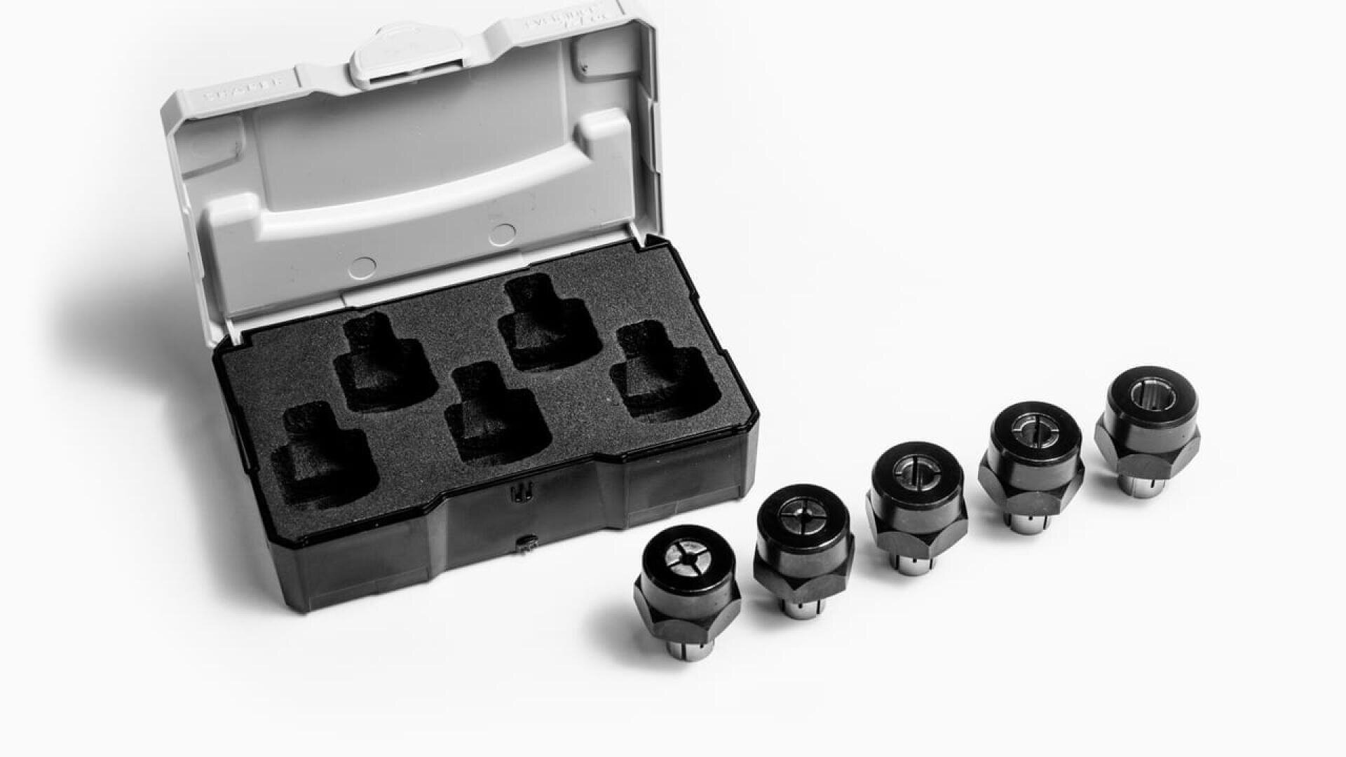Image en noir et blanc d'un petit boîtier ouvert avec cinq douilles à l'intérieur, présenté à côté de cinq freins de roue ou écrous de roue en métal disposés en rangée sur une surface blanche.