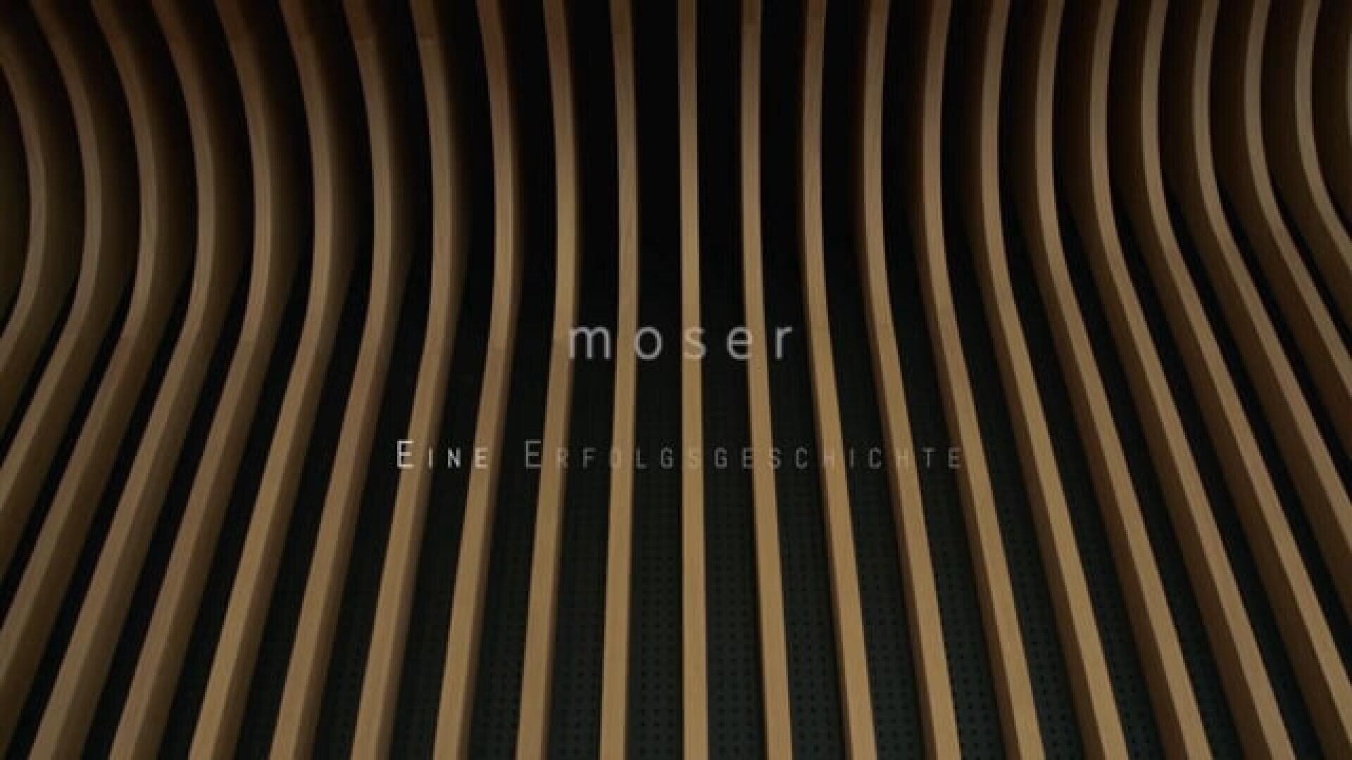 Gebogene vertikale Holzlatten bilden ein wellenförmiges Muster auf dunklem Hintergrund. In der Mitte erscheint der Text "moser" und "Eine Erfolgsgeschichte".