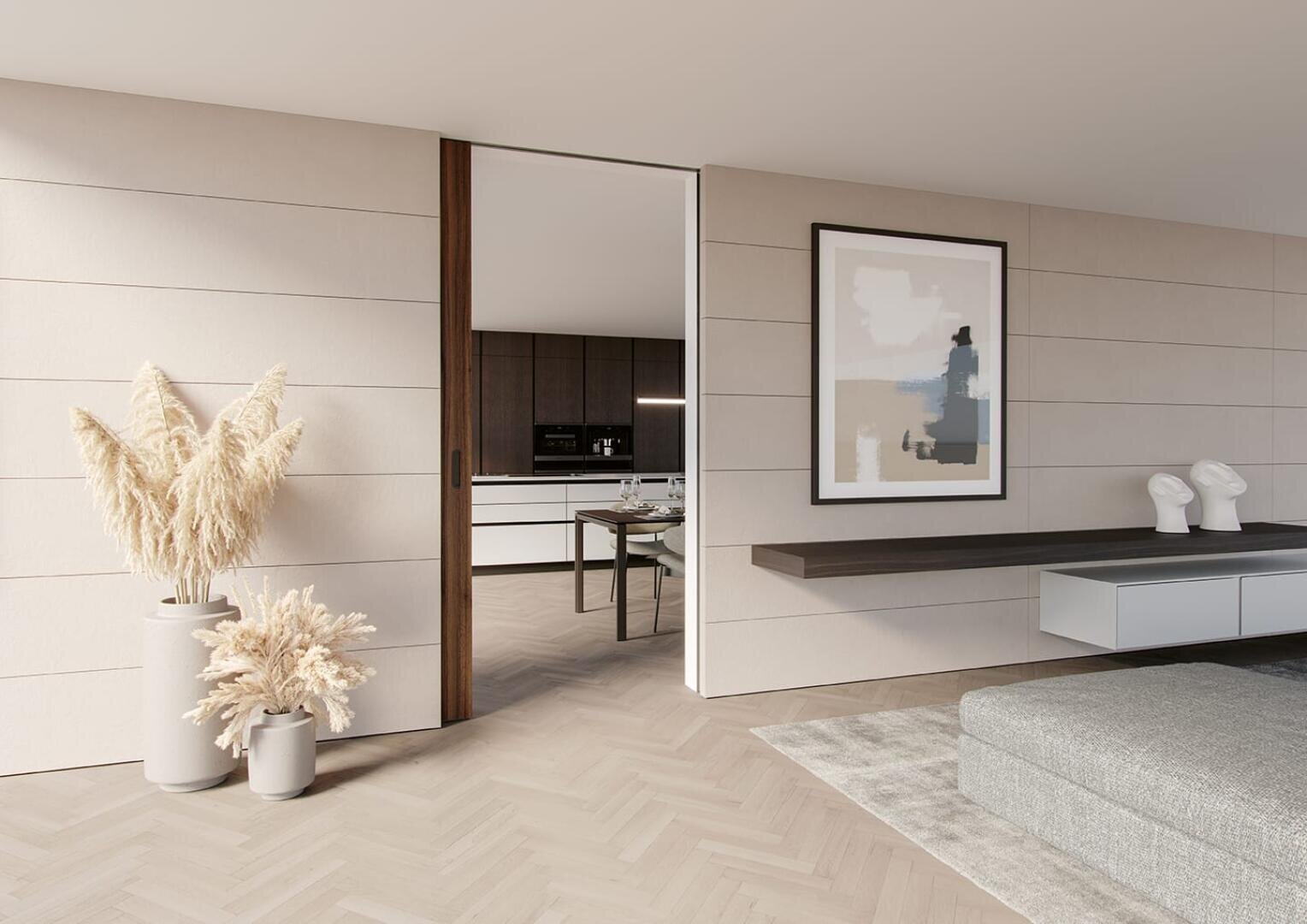 Minimalistischer Wohnraum mit hellen Holzböden, neutralen Wandpaneelen, Vasen mit Pampasgras, moderner abstrakter Kunst, einem schwebenden Regal mit zwei Skulpturen und einem Blick in eine schlichte, moderne Küche und einen Essbereich.