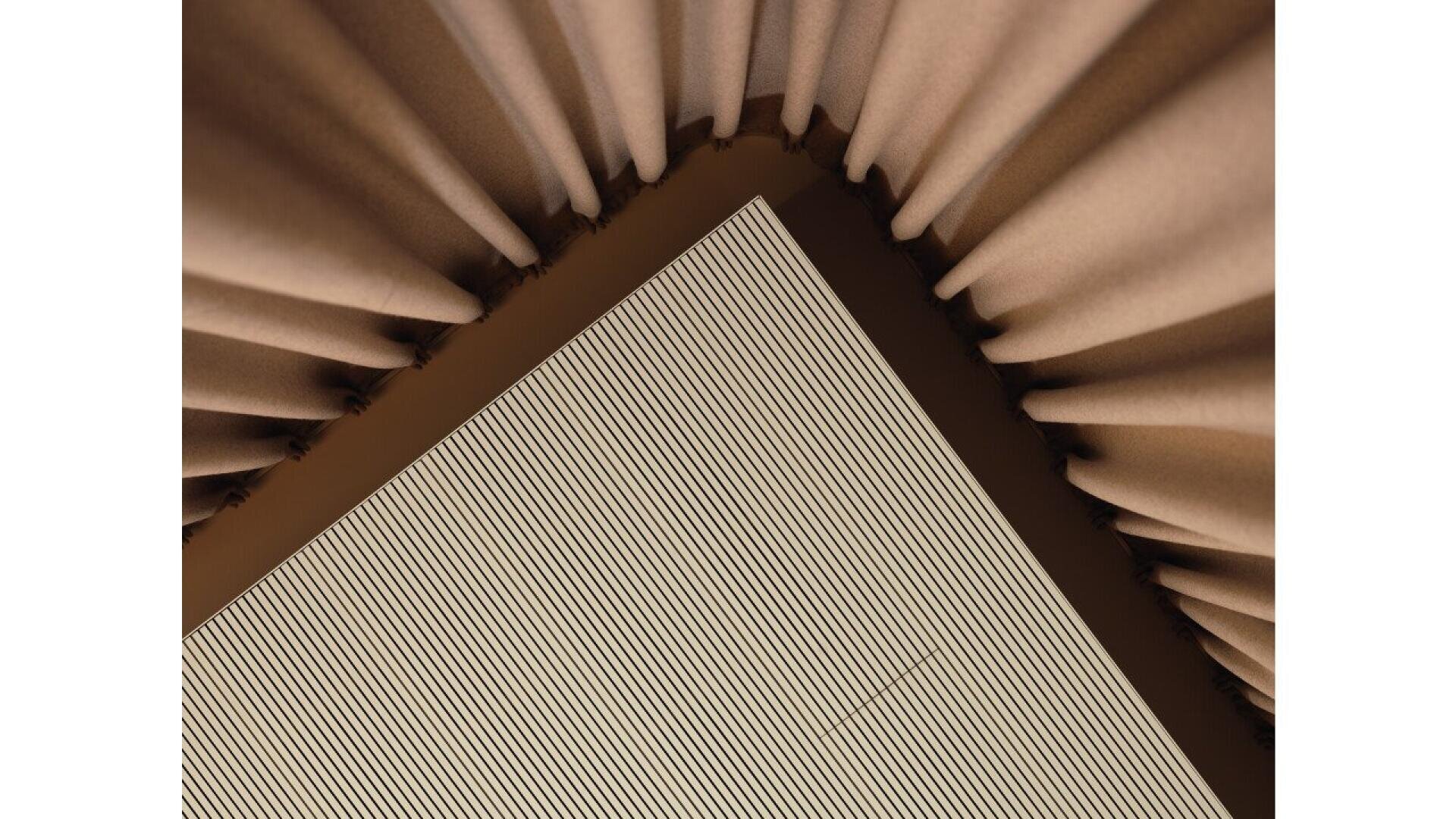 Photo en gros plan d'un coin où deux surfaces texturées se rencontrent ; un côté présente des panneaux verticaux nervurés, tandis que l'autre présente des plis de tissu marron doux et incurvés, créant une composition géométrique abstraite.