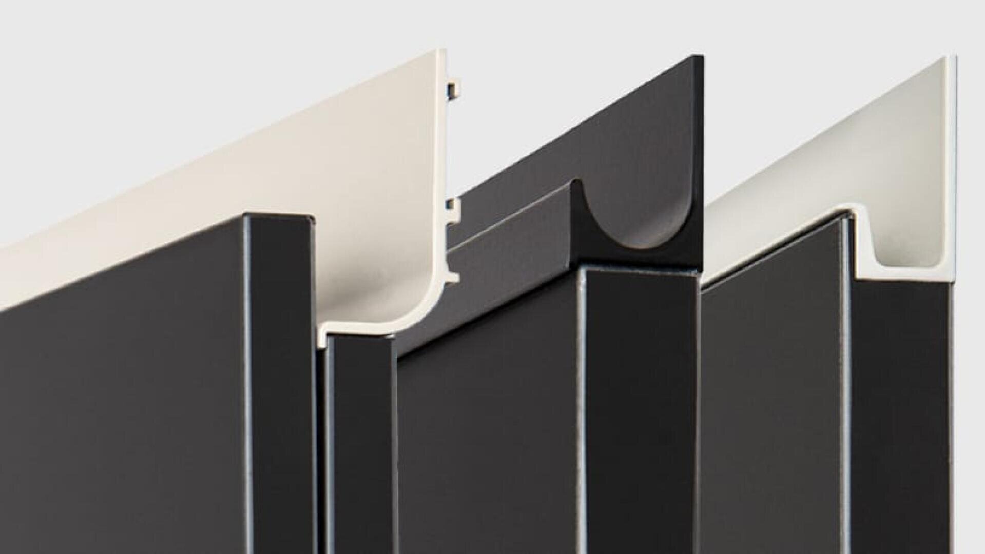 Drei Nahaufnahmen von schwarz-weißen Aluminium- oder Metallprofilen werden vertikal auf einem hellgrauen Hintergrund aufgereiht und heben ihre Formen, Kanten und Innenkonturen hervor.