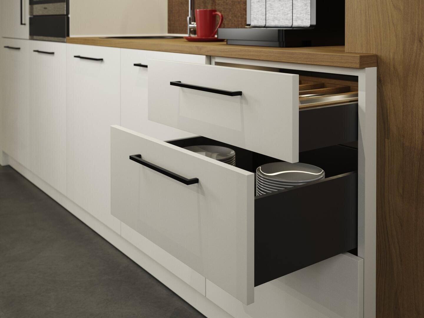 Deux tiroirs de cuisine blancs sont ouverts. Dans le tiroir supérieur se trouvent des couverts et dans le tiroir inférieur une pile d'assiettes blanches. Les armoires ont des poignées noires et au-dessus se trouve un plan de travail en bois.