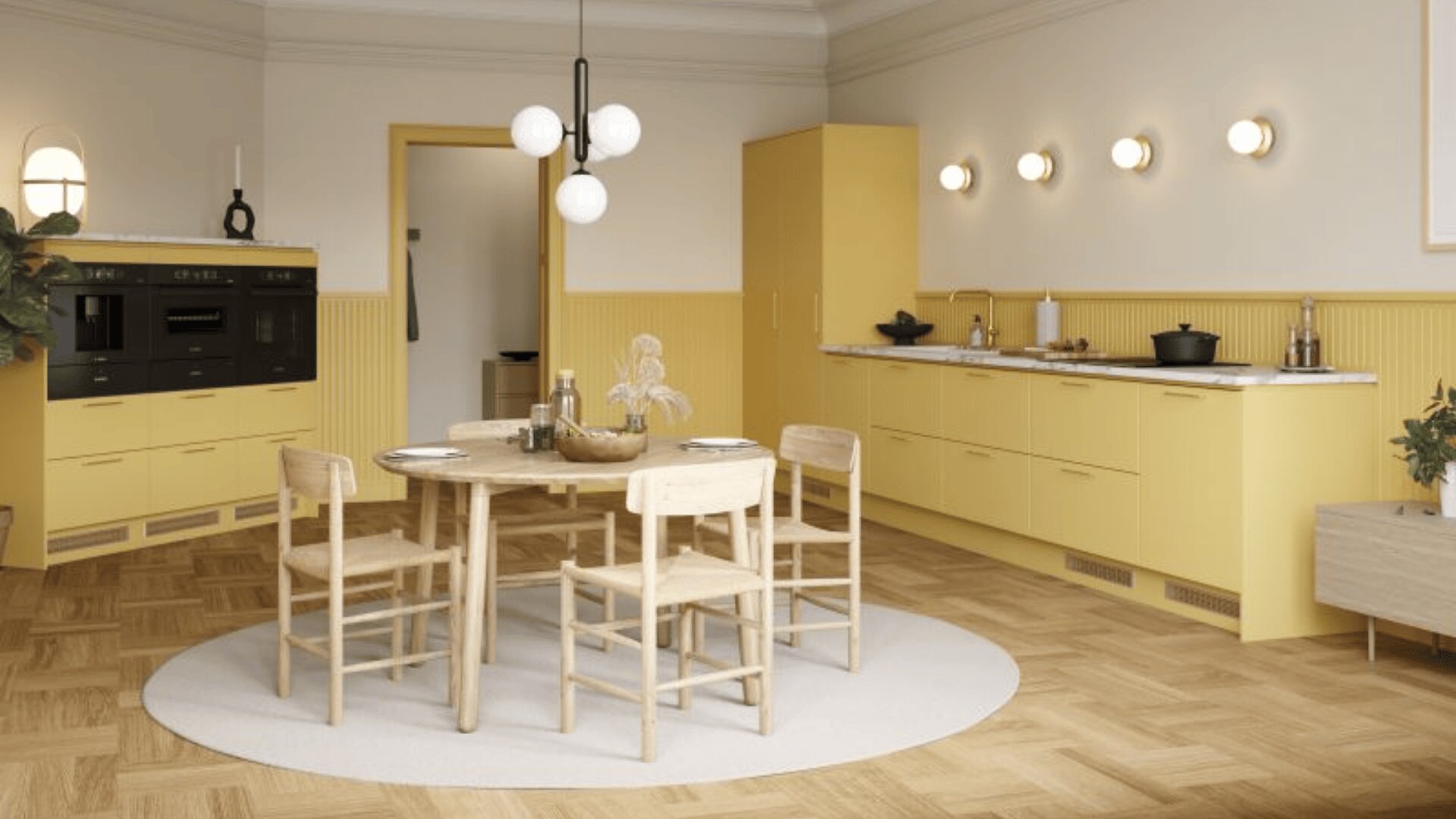 Moderne Küche mit gelben Schränken, einem runden Esstisch aus Holz, vier Stühlen, hellem Holzfußboden, Wandleuchten und minimalem Dekor. Im Hintergrund sind eine Topfpflanze und Küchengeräte zu sehen.